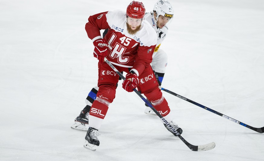 Le defenseur lausannois Jonas Junland , gauche, lutte pour le puck avec l&#039;attaquant fribourgeois Julien Sprunger, droite, lors de la rencontre du championnat suisse de hockey sur glace de Nationa ...