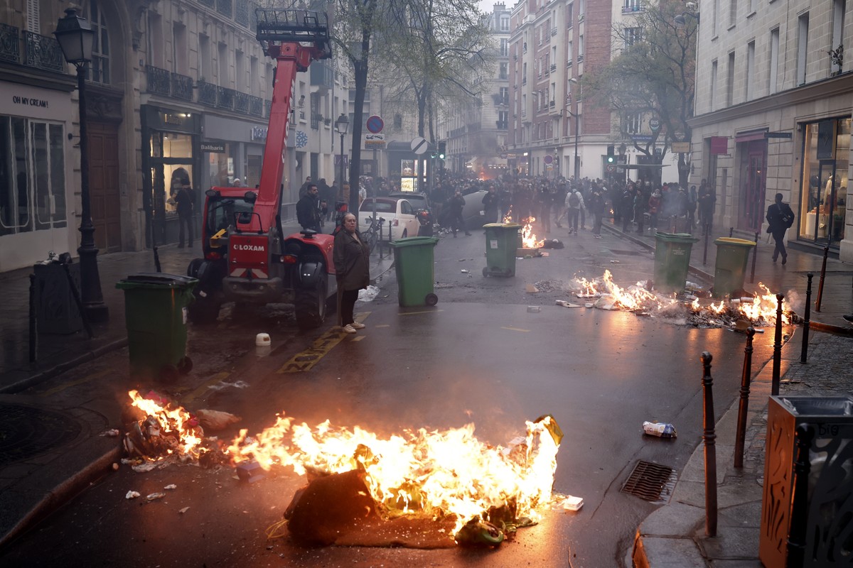 epa10572796 Fires burn during clashes at a rally near the Constitutional Council after the proclamation of their decision about the government's pension reform text, in Paris, France, 14 April 20 ...