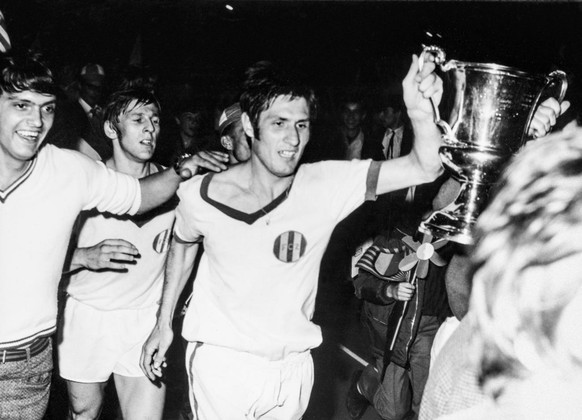 Die FCZ-Spieler Rosario Martinell, rechts, und Christian Winiger, hinten, mit dem Meisterpokal auf einer Ehrenrunde im Letzigrundstadion in Zuerich. Der FC Zuerich gewinnt am 26. Juni 1968 das Spiel d ...