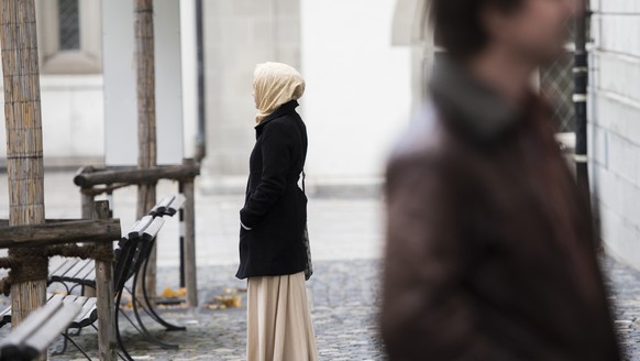 Ein junge Frau mit Kopftuch verweilt vor dem St. Galler Verwaltungsgericht anlaesslich der Gerichtsverhandlung zum Kopftuchverbot im Schulunterricht am Freitag, 7. November 2014, in St. Gallen. Das St ...