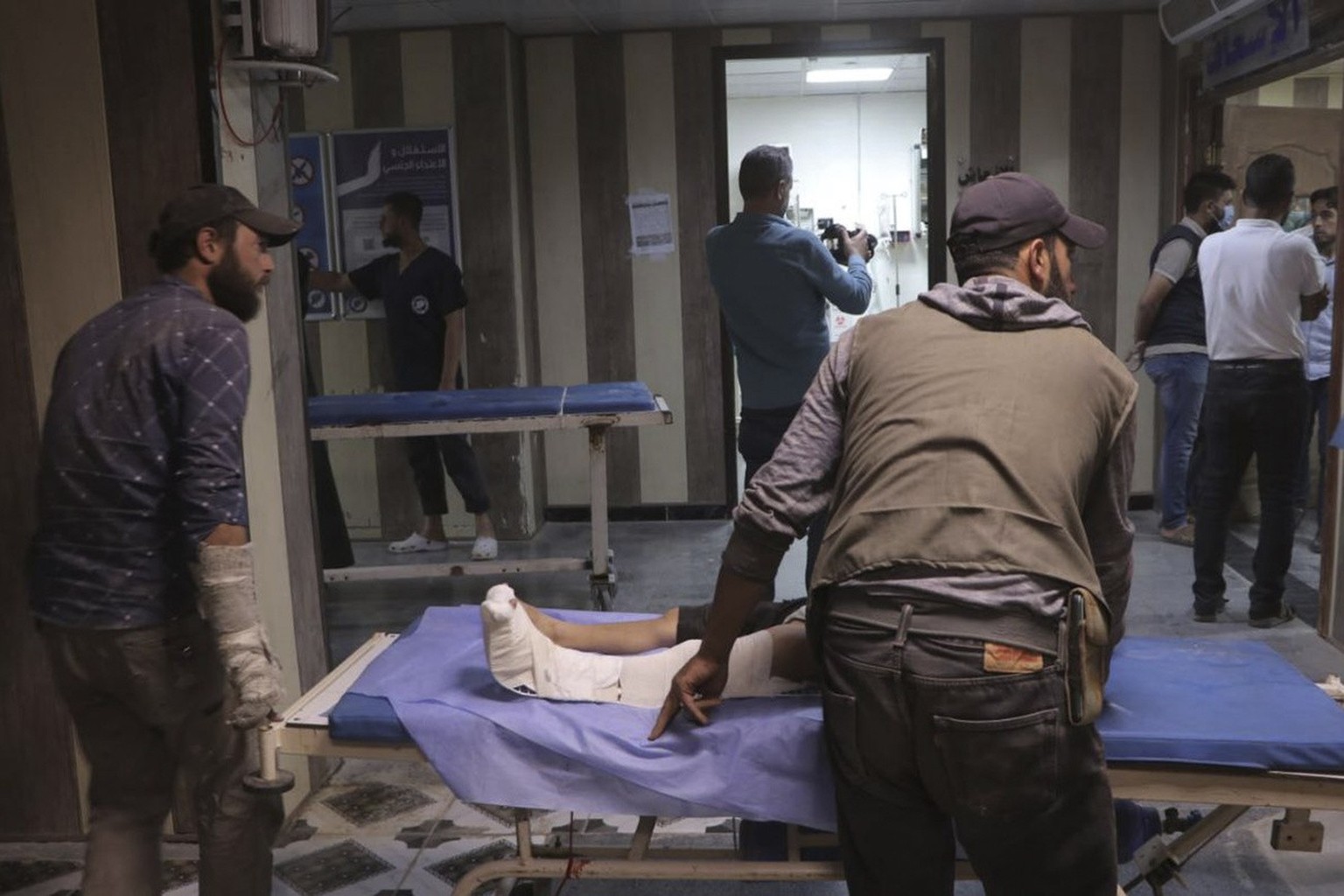 In this photo provided by the Syrian Civil Defense White Helmets, people who were injured by shell strucks arrive to receive treatment at a hospital in Idlib, Syria, Thursday, Oct. 5, 2023. A drone at ...