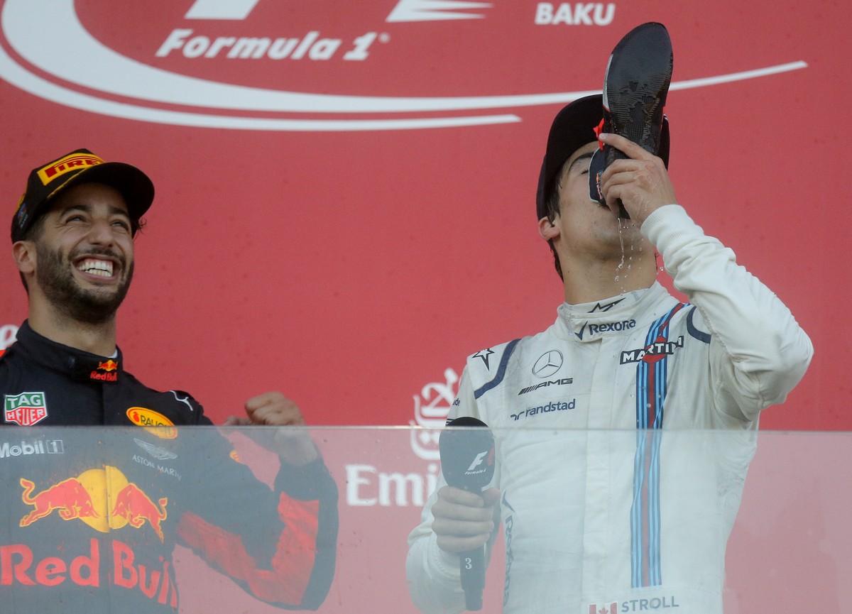 Williams driver Lance Stroll of Canada takes a celebratory drink from the boot of Red Bull driver Daniel Ricciardo of Australia, left, who is winner the Formula One Azerbaijan Grand Prix in Baku, Azer ...
