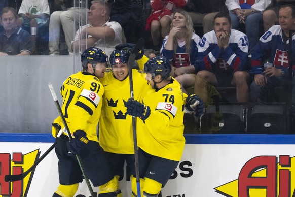 epa12995419 Sweden's Jakob Silfverberg, center, celebrates his 2-1 goal with Sweden's Carl Grundstrom, left, and Sweden's Rasmus Asplund, right, during the 2026 IIHF Men's Ice Hock ...