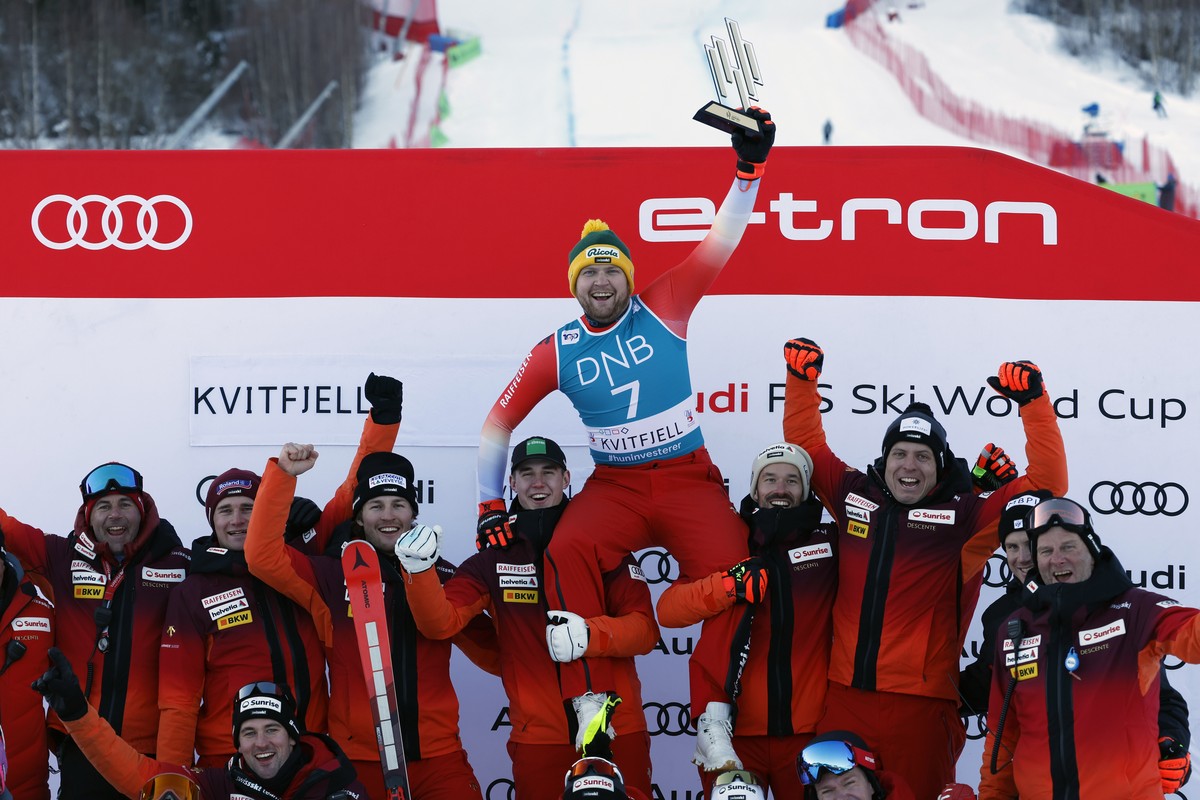 Switzerland's Niels Hintermann celebrate with the team after winning an alpine ski, men's World Cup downhill race, in Kvitfjell, Norway, Saturday, Feb. 17, 2024. (AP Photo/Alessandro Trovati ...