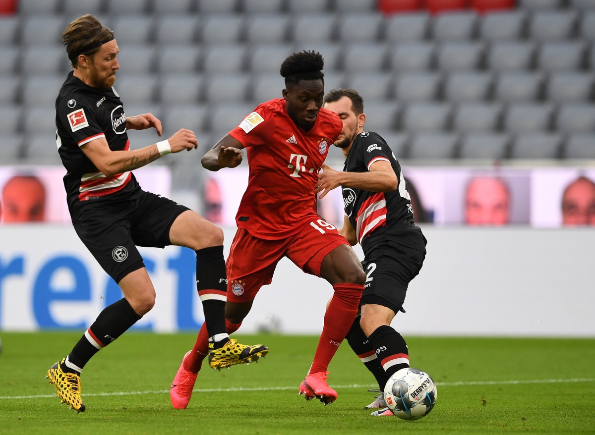 epa08454686 Bayern Munich's Canadian midfielder Alphonso Davies (C) and Fortuna Duesseldorf's Austrian midfielder Kevin Stoeger (R) vie for the ball during the German Bundesliga soccer match ...