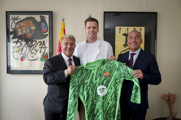 epa11638880 A handout photo made available by FC Barcelona showing Polish goalkeeper Wojciech Szczesny (C) holding his jersey between FC Barcelona President ??Joan Laporta (L) and FC Barcelona&#039;s  ...