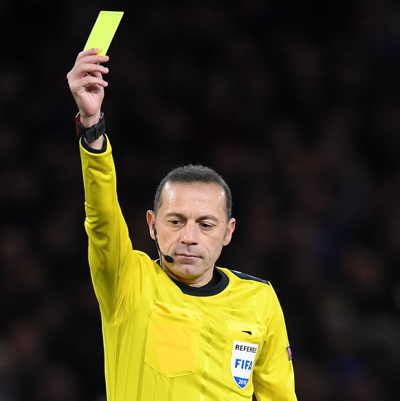 epa06547563 Referee Cuneyt Cakir shows the yellow card to Barcelona&#039;s Ivan Rakitic (L) during the UEFA Champions League Round of 16, first leg soccer match between Chelsea FC and FC Barcelona at  ...