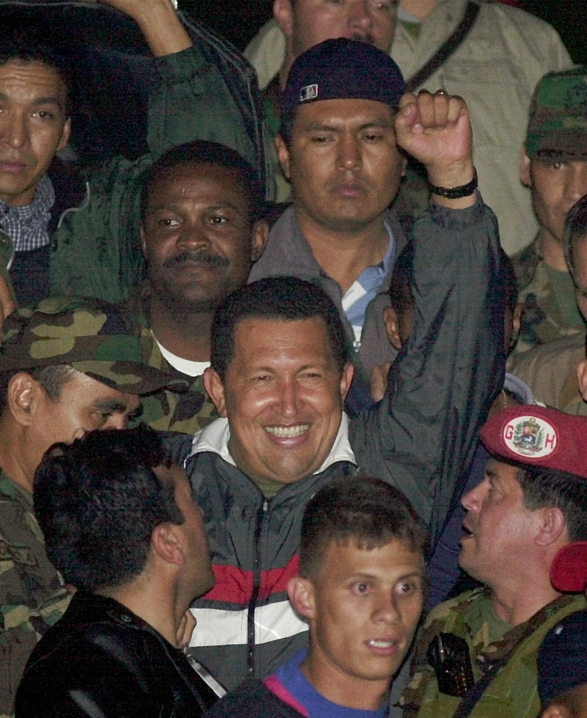 FILE - In this April 14, 2002 file photo, Venezuela's President Hugo Chavez gestures to supporters as he arrives to Miraflores presidential palace after being freed by his military captors two da ...