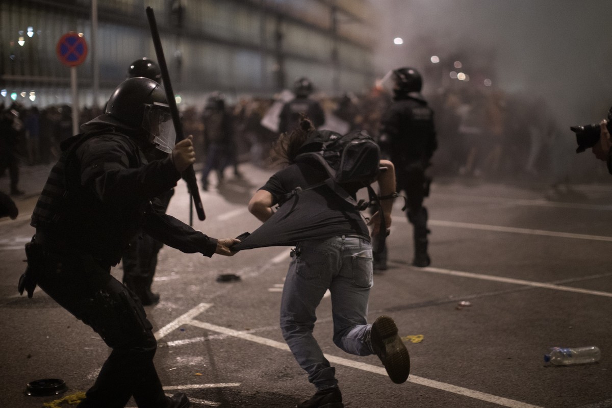 Demonstrators run away from Police officers outside El Prat airport in Barcelona, Spain, Monday, Oct. 14, 2019. Riot police have charged at protesters outside Barcelona's airport after the Suprem ...