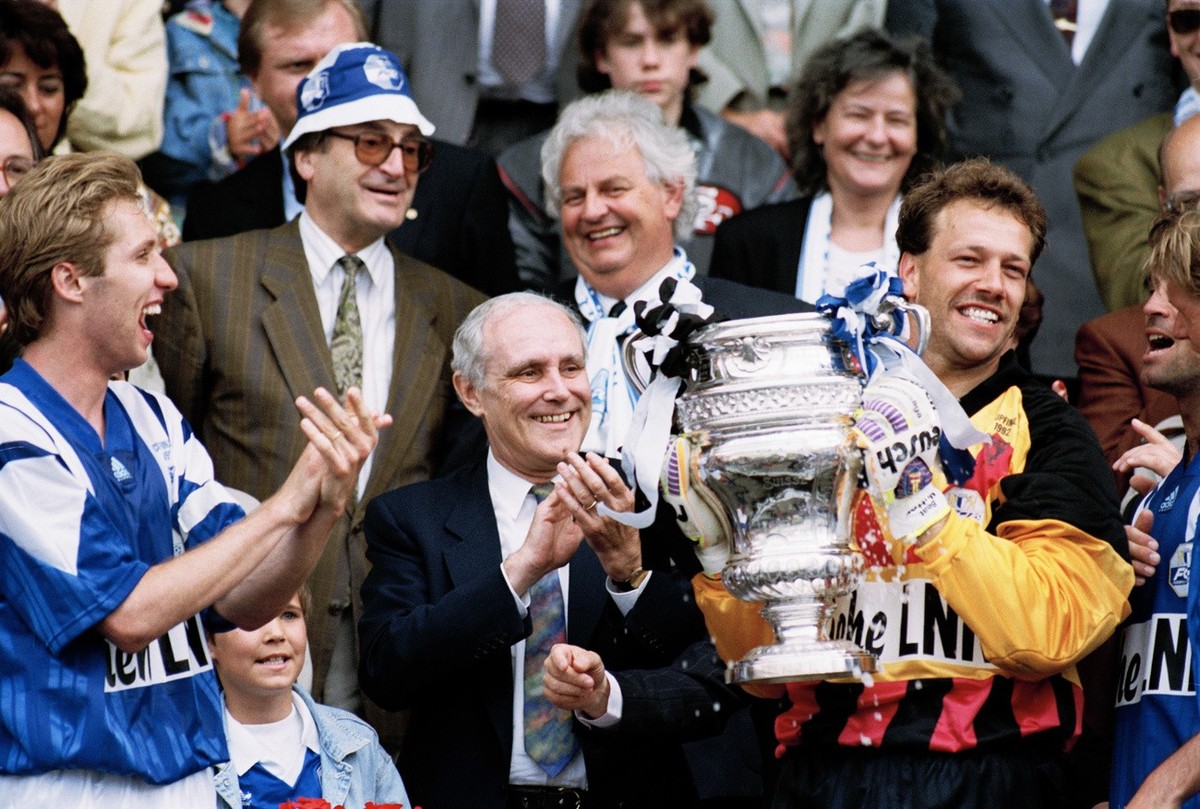 Beat Mutter, Torhueter des FC Luzern, haelt nach dem 3:1 Sieg im Cupfinal gegen AC Lugano am 8. Juni 1992 im Wankdorf-Stadion in Bern den Pokal, beklatscht von Spieler Adrian Knup, links, und Bundesra ...