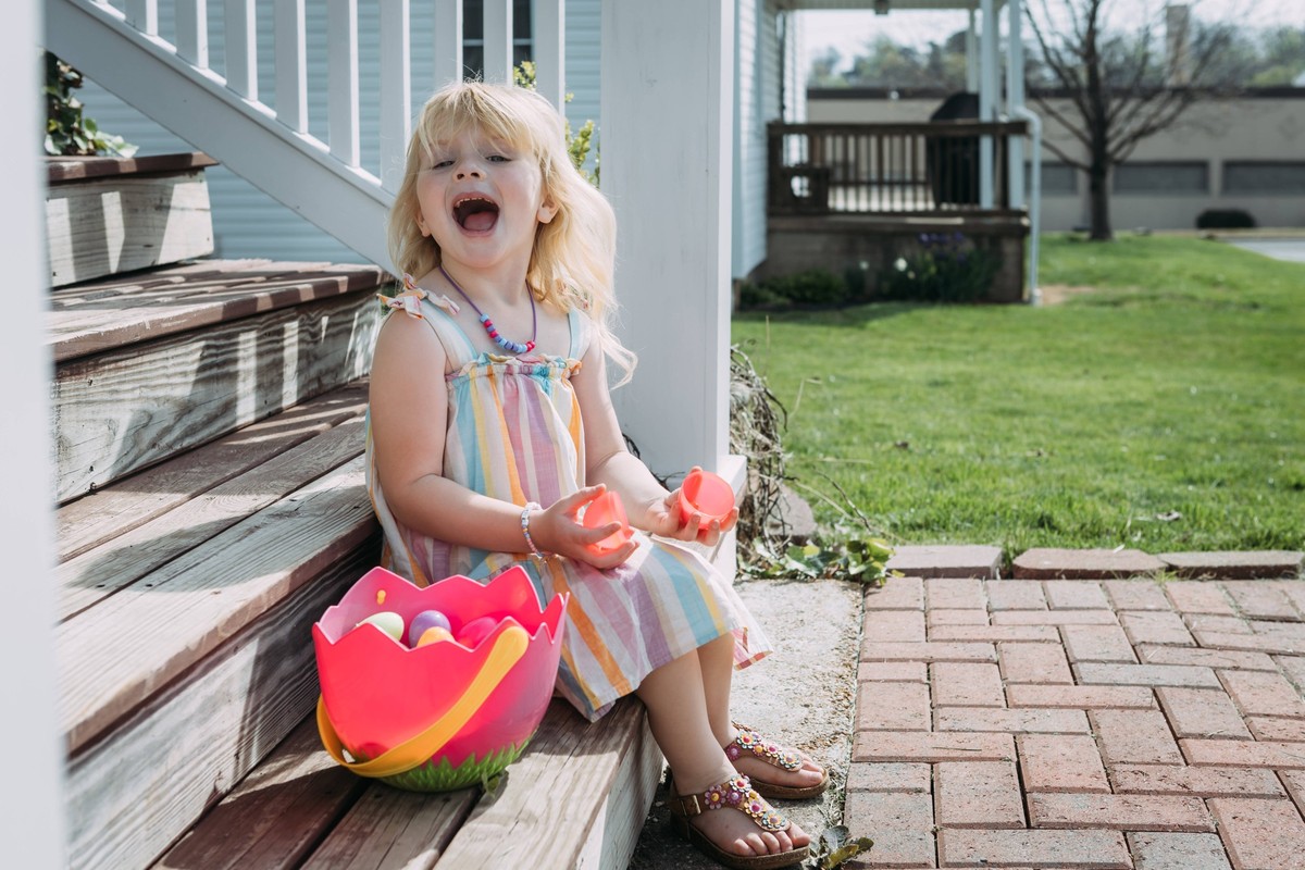 Excited young child sorting through Easter basket on front porch Jackson, Missouri, United States R_WEKW250321A-1688056-01 ,model released, Symbolfoto
