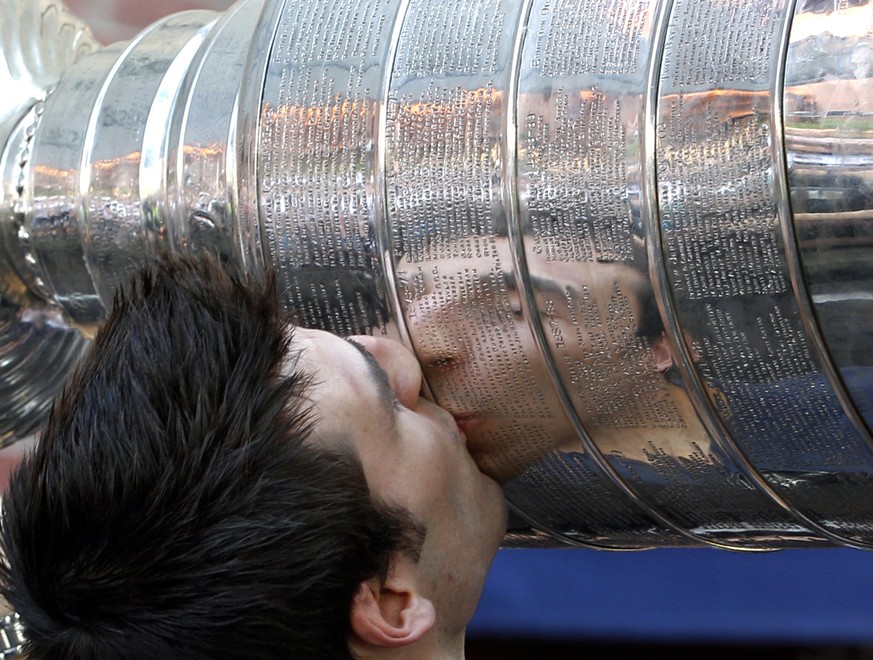 FILE - Boston Bruins&#039; Patrice Bergeron is reflected as he kisses the Stanley Cup at Tia&#039;s Restaurant in Boston on Thursday, June 16, 2011, one day after the Bruins beat the Vancouver Canucks ...