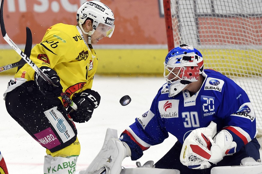 Der Zuercher Torhueter Lukas Flueeler, rechts, und der Berner Ryan Lasch, links, in Erwartung des Pucks, waehrend dem Eishockey-Meisterschaftsspiel der National League A zwischen den ZSC Lions und dem ...