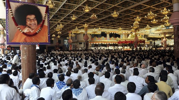 epa02704292 Hundreds of devotees gather inside the Sri Kulwant Hall in Prasanthi Nilayam to attend the funeral ceremony of Hindu holy man Sathya Sai Baba in Puttaparti, about 450 kilometers from Hyder ...
