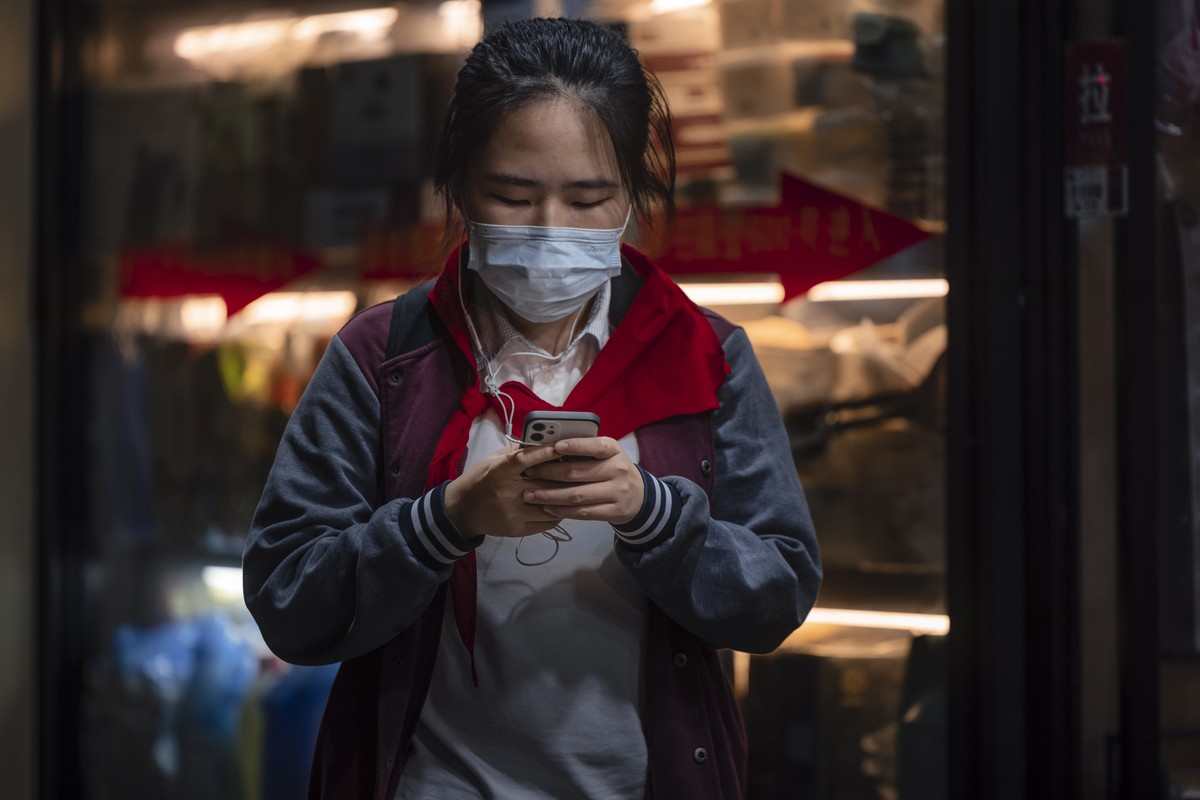 epa09481246 A school girl uses her phone on the street in Shanghai, China, 22 September 2021. Douyin, China's version of the famous short video app TikTok, will limit the use of the platform for  ...