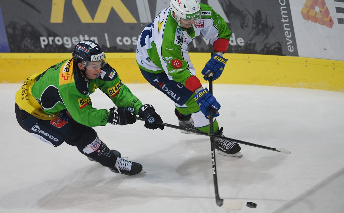 Ambri's player Dominic Zwerger, left, fights for the puck with Davos's player Otso Rantakari, right, during the preliminary round game of National League A (NLA) Swiss Championship 2019/20 b ...