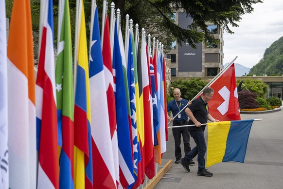 epa11410048 Bernhard (L) and Daniel Egger (R) place the flags of Switzerland and Ukraine during final preparations ahead the Summit on Peace in Ukraine, in Stansstad near Lucerne, Switzerland, 14 June ...