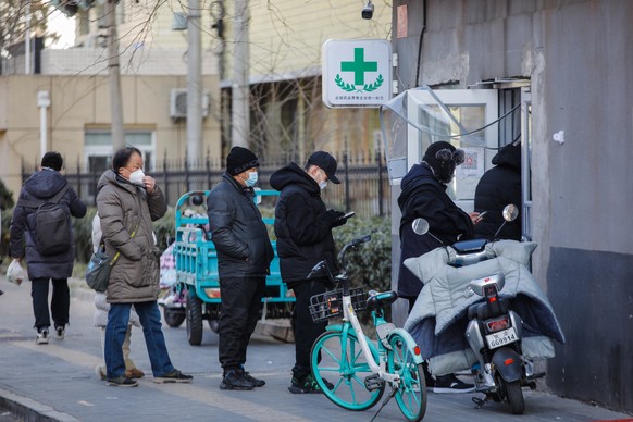 epa10375327 People line up to buy medication in Beijing, China, 21 December 2022. Chinese authorities have reported five more deaths as fever clinics or consulting rooms and hospital beds have been se ...