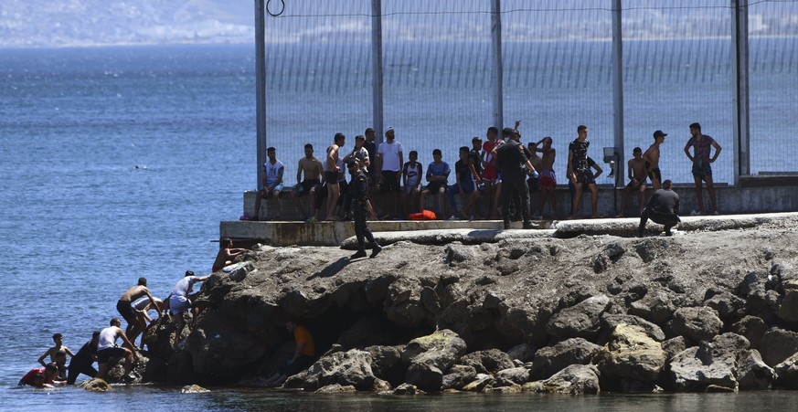 Spanish Guardia Civil officers try to stop people from Morocco entering into the Spanish territory at the border of Morocco and Spain, at the Spanish enclave of Ceuta on Monday, May 17, 2021. Authorit ...