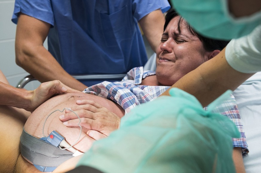 epa06110559 Eniko Milo (R) is seen during labor while giving birth to her son Levente in the Josa Andras Education Hospitals Obstetrics Gynecology Department in Nyiregyhaza, 227 km east of Budapest,  ...