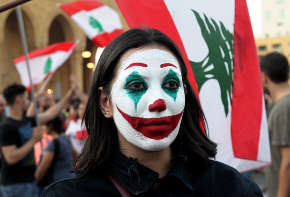 epaselect epa07934768 A lebanese girl paint her face with Lebanes flag color where Protesters wave Lebanese flags shout anti-government slogans during a protest in downtown Beirut, Lebanon, 19 October ...