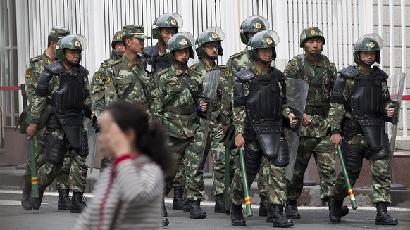 FILE - In this May 23, 2014 file photo, paramilitary policemen with shields and batons patrol near the People&#039;s Square in Urumqi, China&#039;s northwestern region of Xinjiang. So far this month,  ...