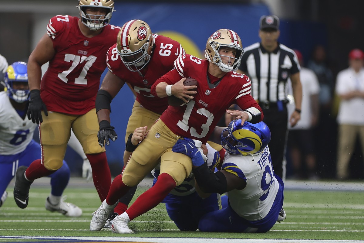 San Francisco 49ers quarterback Brock Purdy (13) is tackled by Los Angeles Rams defensive tackle Braden Fiske, bottom middle, and defensive tackle Kobie Turner, bottom right, during the second half of ...