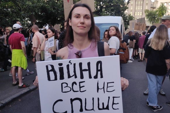 epa12257264 A protester holds a sign reading ?War cannot be an excuse for everything? during a demonstration in Kiev, Ukraine, 23 July 2025. Thousands of Ukrainians gathered on the second day of prote ...