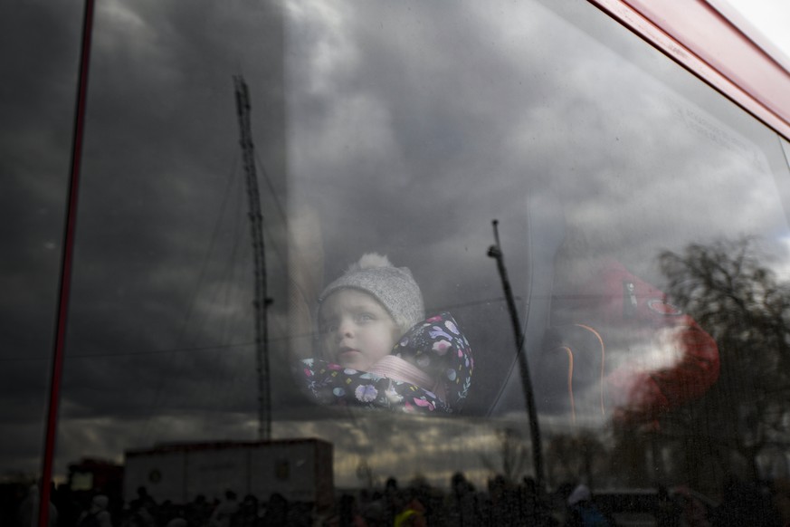 A refugee child fleeing the conflict from neighboring Ukraine sits in a bus at the Romanian-Ukrainian border, in Siret, Romania, Monday, Feb. 28, 2022. (AP Photo/Andreea Alexandru)