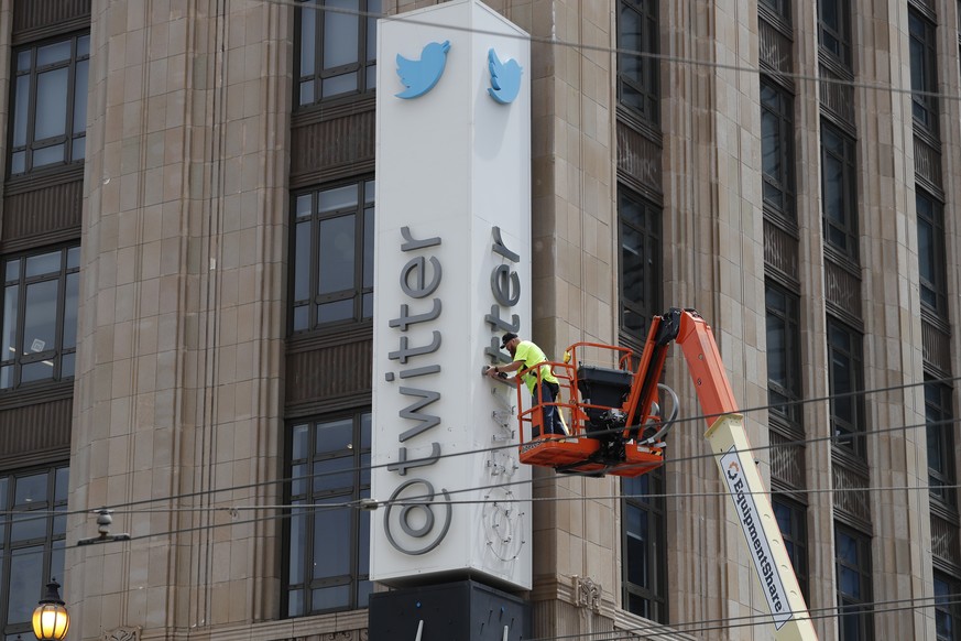 epa10766820 Workers remove letters from the iconic vertical Twitter sign at the company?s headquarters after Twitter owner Elon Musk annouced the rebranding of the social media platorm to X in San Fra ...