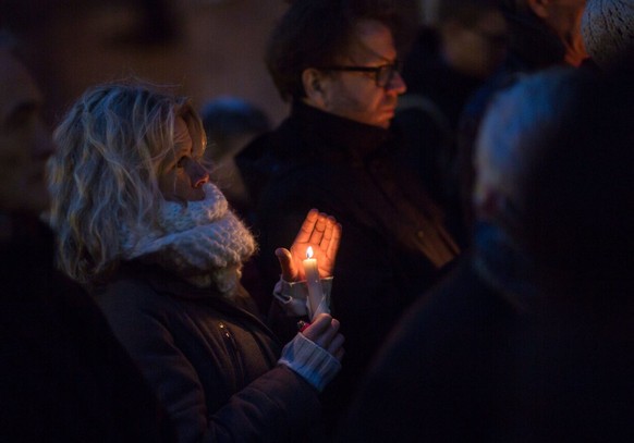 epa05100338 A woman holds a candle at Paulsplatz during a memorial service for the victims of the terrorist attack in Istanbul on 12 January 2016 in Frankfurt, Germany, 13 January 2016. Representative ...
