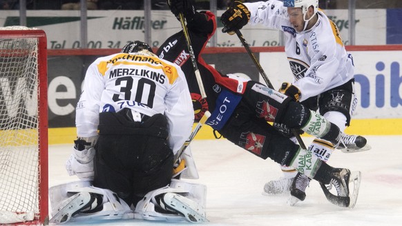 Berns Thomas Ruefenacht, Mitte, im Duell mit Luganos Goalie Elvis Merzlikins, links, und Massimo Ronchetti, rechts, waehrend dem Eishockey National League Spiel zwischen dem SC Bern und dem HC Lugano, ...