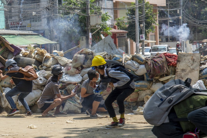 Armed riot policemen charge after firing teargas a rubber bullets as anti-coup protesters abandon their makeshift barricades and run in Yangon, Myanmar Tuesday, March 16, 2021. (AP Photo)