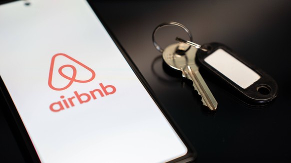 Airbnb Platform Photo Illistrations The Airbnb logo appears on a mobile phone screen next to a key in Athens, Greece, on February 24, 2026. Athens Greece PUBLICATIONxNOTxINxFRA Copyright: xNikosxPekia ...
