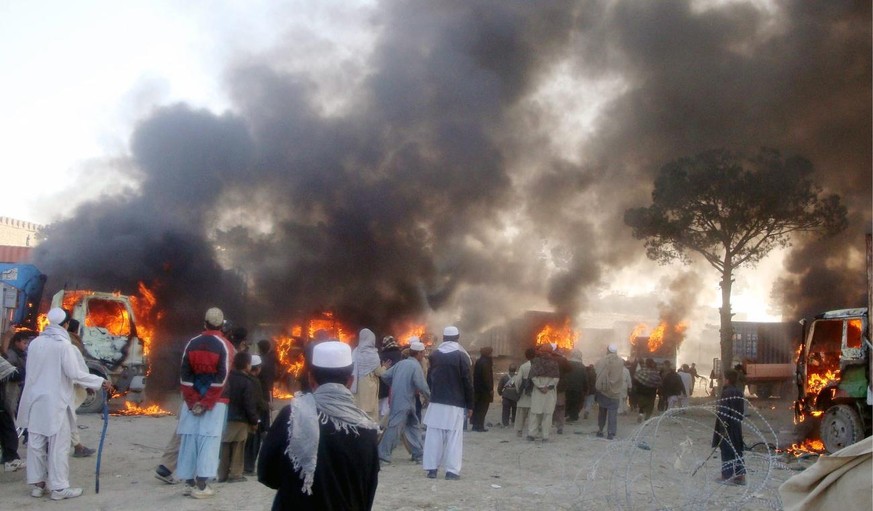 epa03119762 Flames rise from vehicles that were set on fire by people protesting against the &#039;Koran burning&#039; allegedly by the US troops in Afghanistan, in Khost, Afghanistan, 24 February 201 ...