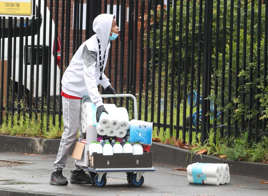 epa08539762 An Amssa youth connect centre volunteer with donated supplies for residents of the Alfred Street public housing tower which remains under tight lockdown over to the coronavirus disease (CO ...