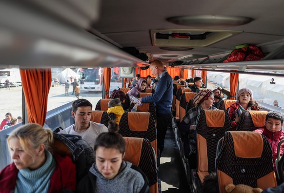 epa10487898 People sit on a bus to evacuate the city in the aftermath of powerful earthquakes, in Hatay, Turkey, February 24, 2023. More than 46,000 people died and thousands were injured after ...