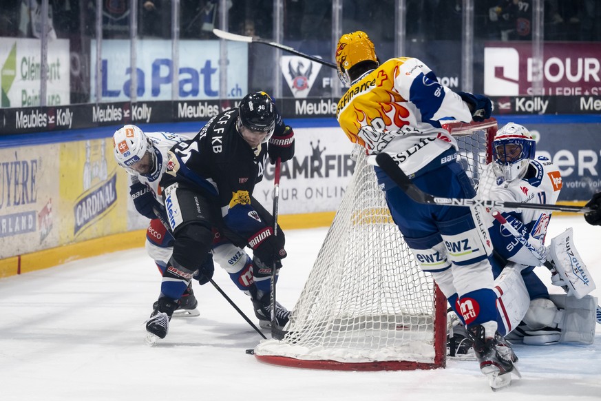 Zuerichs Dominik Diem, links, und Gotterons Matthias Rossi, Mitte, kaempfen um den Puck, an der Seite von Zuerichs PostFinance Top Scorer Dean Kukan, und Zuerichs Torhueter Simon Hrubec, beim Eishocke ...