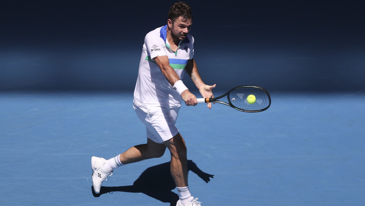 Switzerland's Stan Wawrinka makes a backhand return to Hungary's Marton Fucsovics during their second round match at the Australian Open tennis championship in Melbourne, Australia, Wednesda ...