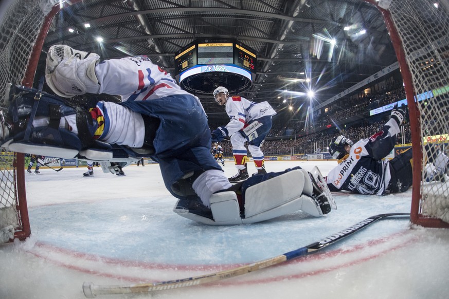 Torhueter Lukas Flueeler, links, vom ZSC bei einer Parade im fuenften Eishockey Playoff-Viertelfinalspiel der National League zwischen dem EV Zug und den ZSC Lions, am Dienstag, 20. Maerz 2018, in der ...