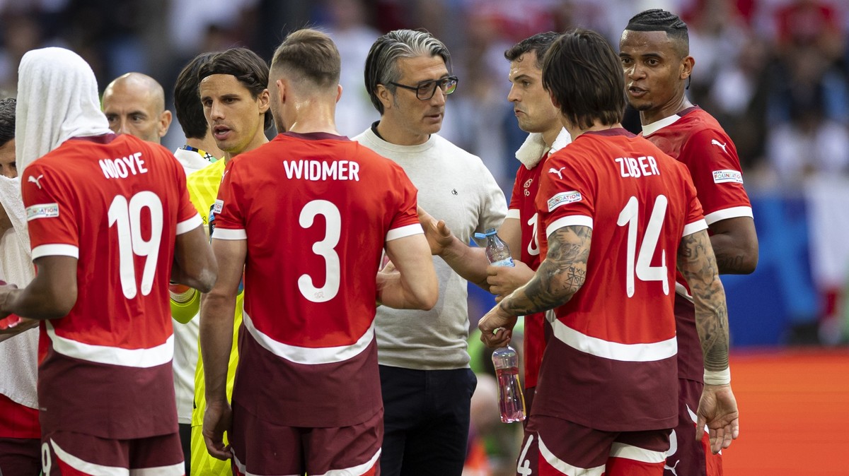 Switzerland's head coach Murat Yakin, center-left, talks to their players Dan Ndoye, Silvan Widmer, Granit Xhaka, Steven Zuber, and Manuel Akanji, from left to right, prior the overtime, during a ...