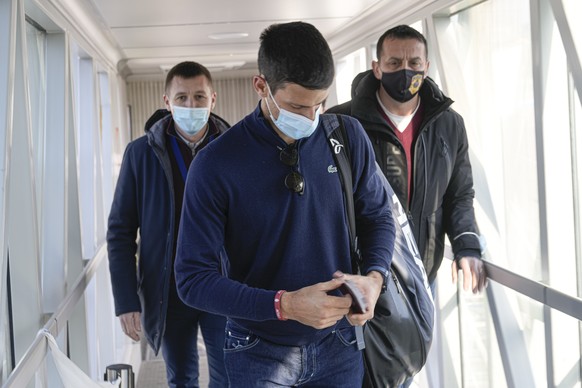 Novak Djokovic looks as his documents after landing in Belgrade, Serbia, Monday, Jan. 17, 2022. Djokovic arrived in the Serbian capital following his deportation from Australia on Sunday after losing  ...