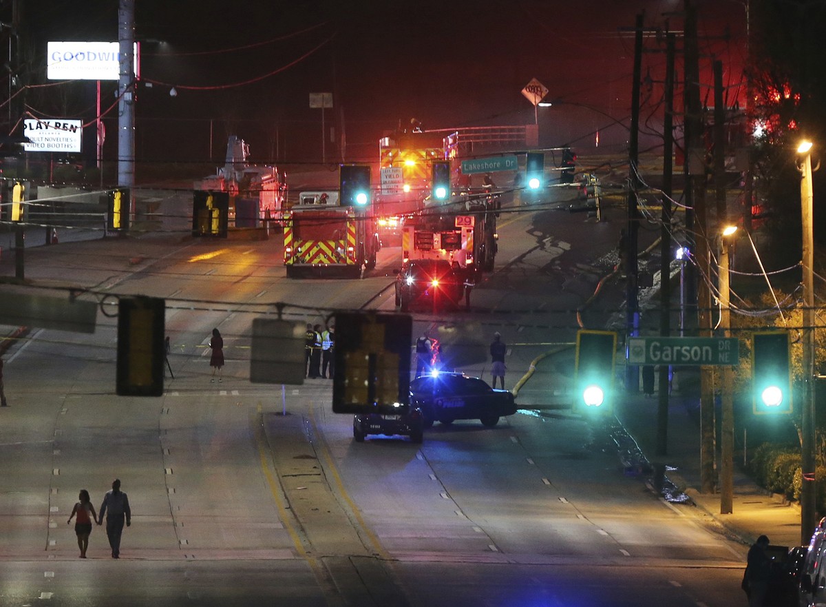 A couple walks away from the scene after a large fire caused an overpass on Interstate 85 to collapse Thursday, March 30, 2017, in Atlanta. Witnesses say troopers told motorists to turn around on the  ...