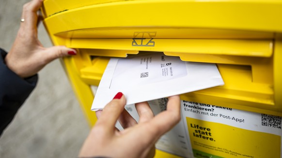 Eine Frau wirft ein Couvert mit Abstimmungsunterlagen fuer die Briefliche Stimmabgabge in einen Briefkasten der Post, am Dienstag, 17. September 2024 in Zuerich. .Die Schweizer Stimmbevoelkerung stimm ...