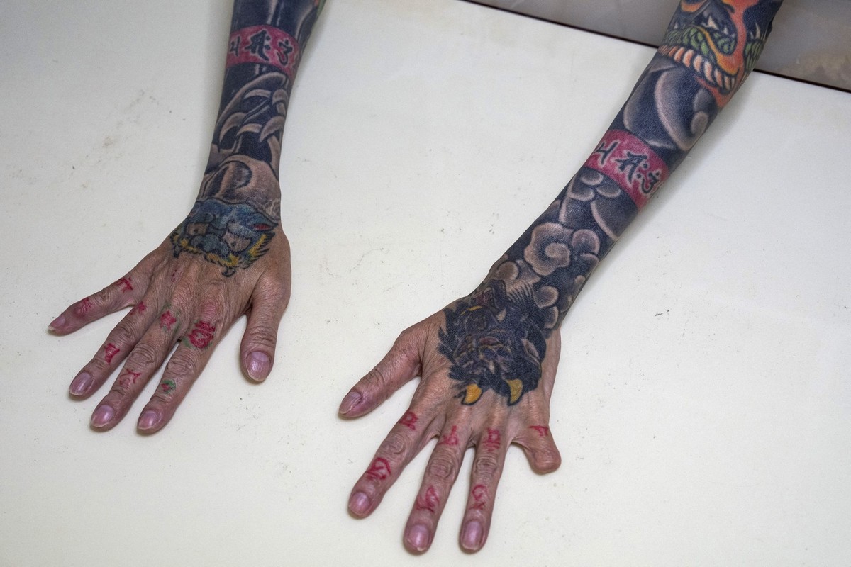 EDITORS NOTE: Graphic content / In this photograph taken on September 28, 2025, retired yakuza Mako Nishimura shows her forearm heavily inked with dragon and tiger tattoos and a missing fingertip, tha ...