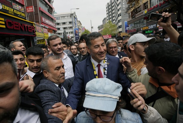 FILE - Sinan Ogan, center, an academician and presidential candidate from ATA alliance, formed of nationalist political parties, is surrounded by supporters during a city tour, in Ankara, Turkey, Thur ...