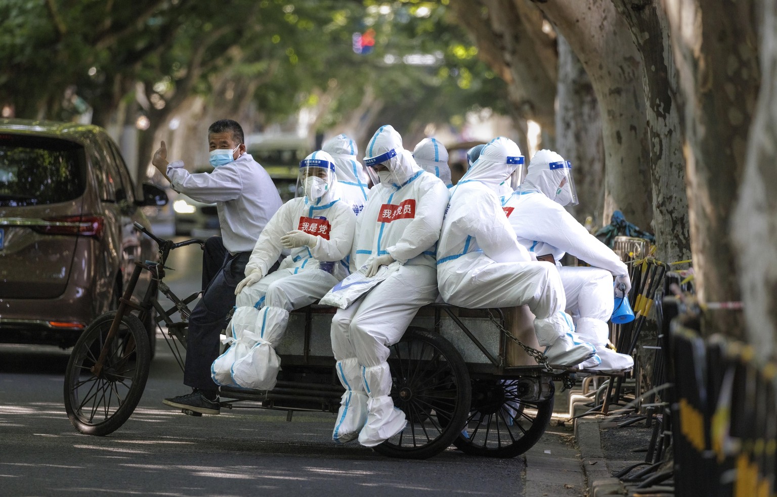 epa10014216 Medical workers ride on a cargo bicycle, in Shanghai, China, 15 June 2022. Makeshift hospitals in Shanghai will be shut down or put on hold from 15 June, except for one on Chongming Island ...