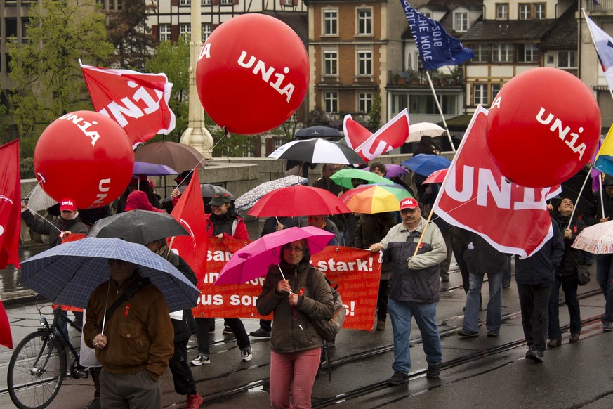 Kundgebungsteilnehmer tragen Transparente und Fahnen am traditionellen 1. Mai-Umzug am Tag der Arbeit, in Basel, am Sonntag, 1. Mai 2016. Der Tag der Arbeit steht dieses Jahr im Zeichen der AHV. Die G ...