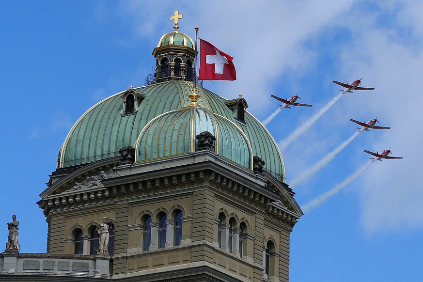 Four Pilatus PC-7 aircrafts of the Swiss Air Force fly over the Swiss Parliament building in Bern, Switzerland June 17, 2016. REUTERS/Ruben Sprich