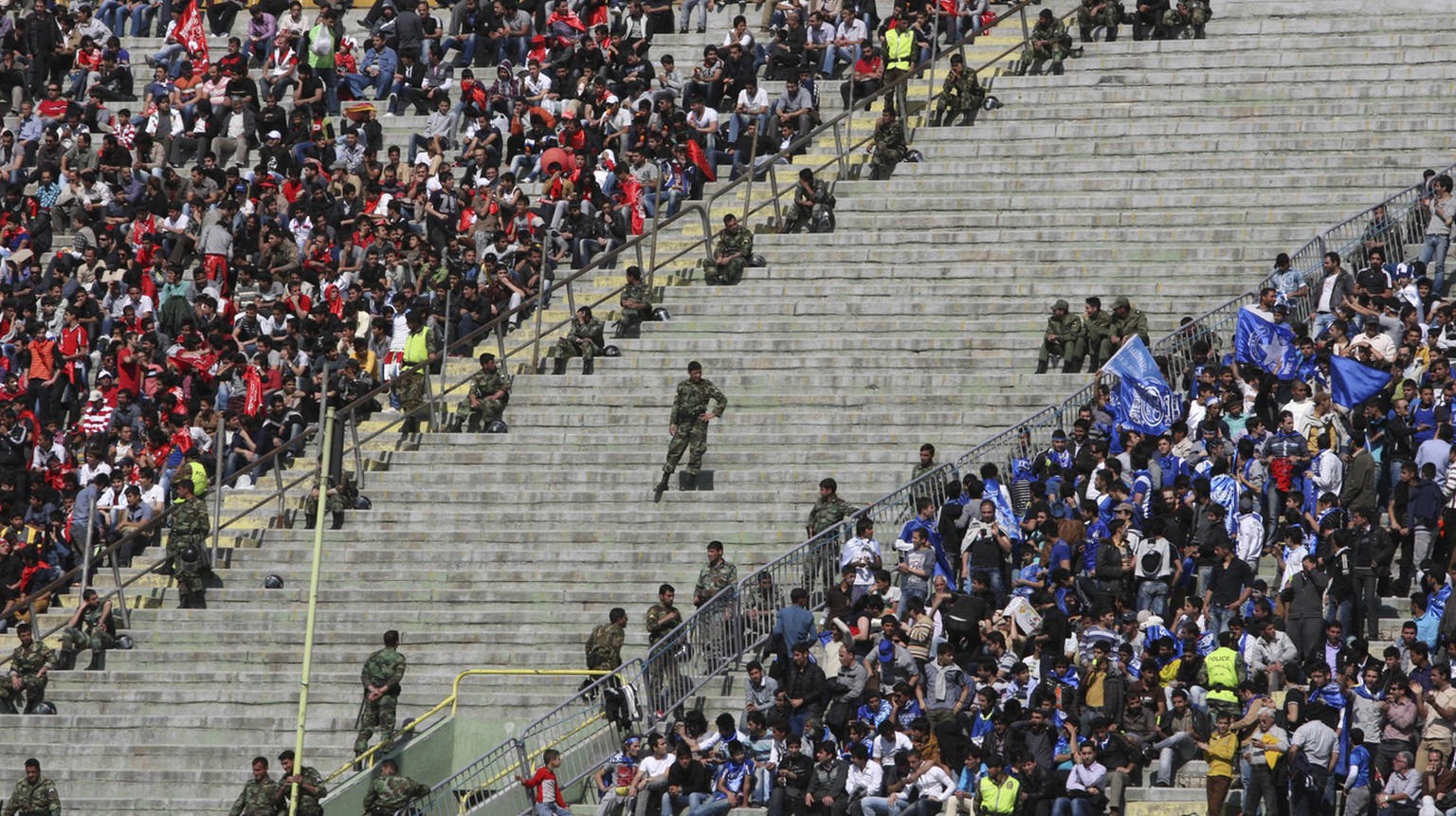 Iranian police officers, center, take position between supporters of soccer teams, Esteghlal, right, and Persepolis, left, in their derby match, during Iran&#039;s premier league, at the Azadi (Freedo ...